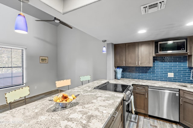 5304 N Paseo De La Terraza, Tucson, AZ 85750 - kitchen with stainless steel appliances, wood finished floors, backsplash, light stone counters, and ceiling fan