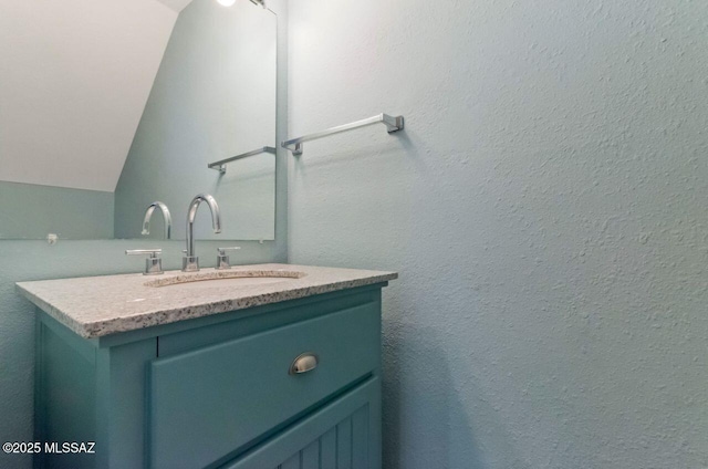 bathroom with vanity and lofted ceiling