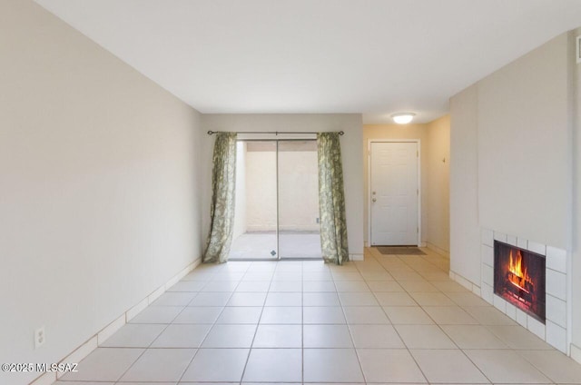 spare room featuring light tile patterned floors and a tiled fireplace