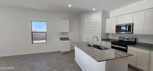 kitchen featuring an island with sink, sink, white cabinets, and stainless steel appliances