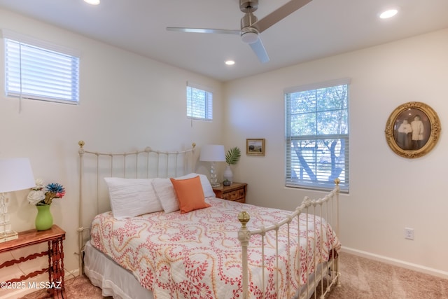 bedroom featuring ceiling fan, carpet, radiator heating unit, and multiple windows