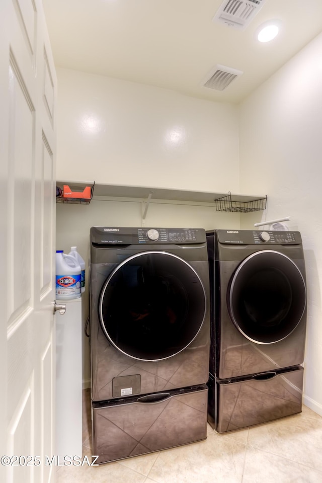 laundry area featuring light tile patterned floors and separate washer and dryer