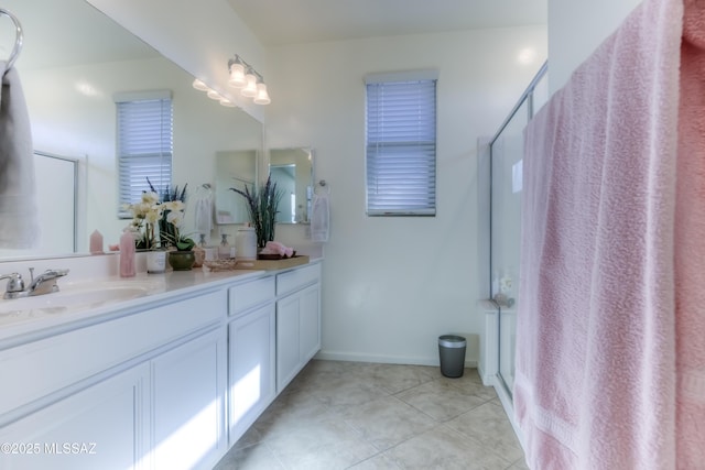 bathroom featuring a shower with shower door, vanity, and tile patterned floors