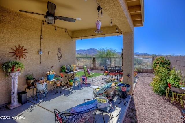 view of patio featuring ceiling fan and a mountain view