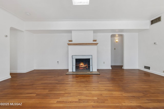 unfurnished living room featuring hardwood / wood-style floors and a tile fireplace