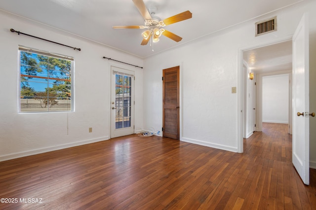 spare room featuring dark wood-type flooring and ceiling fan