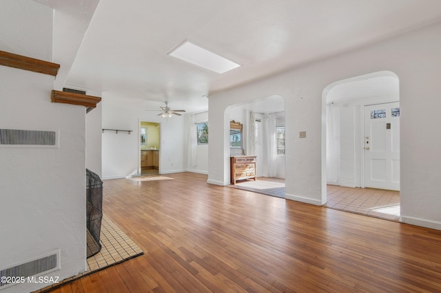 unfurnished living room featuring ceiling fan and light hardwood / wood-style flooring