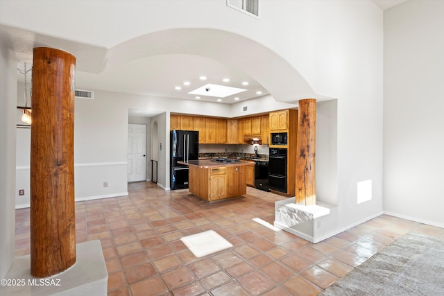 kitchen with black appliances, light tile patterned floors, and a center island