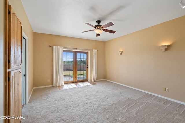 empty room featuring ceiling fan, light colored carpet, and french doors