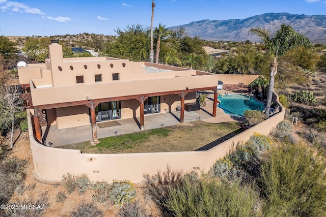 rear view of property featuring a patio area and a mountain view