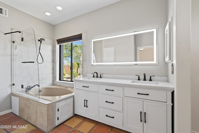 bathroom featuring tiled shower / bath combo, vanity, and tile patterned flooring