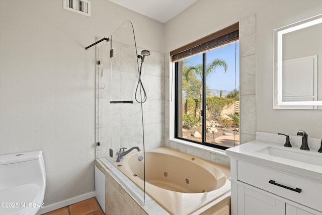 bathroom featuring tile patterned flooring, toilet, vanity, and a healthy amount of sunlight