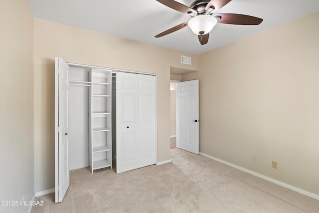 unfurnished bedroom featuring ceiling fan, light colored carpet, and a closet