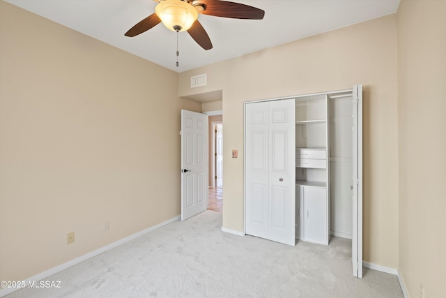 unfurnished bedroom with ceiling fan, light colored carpet, and a closet