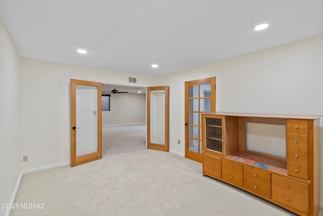 unfurnished living room featuring light carpet, french doors, and ceiling fan