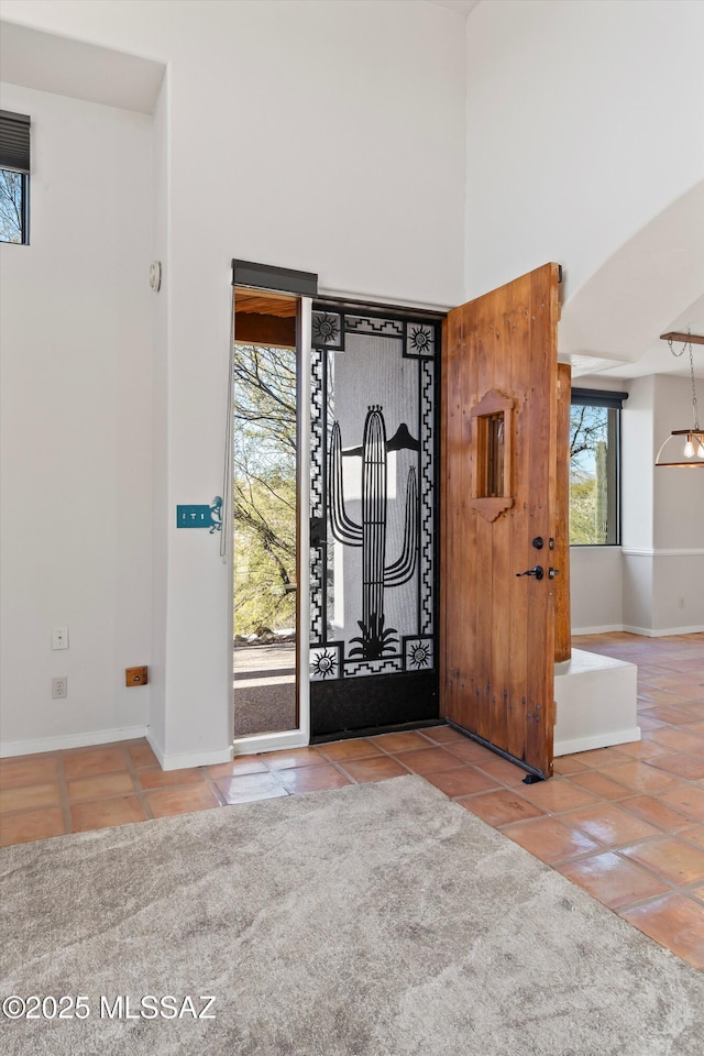 tiled entryway featuring a high ceiling