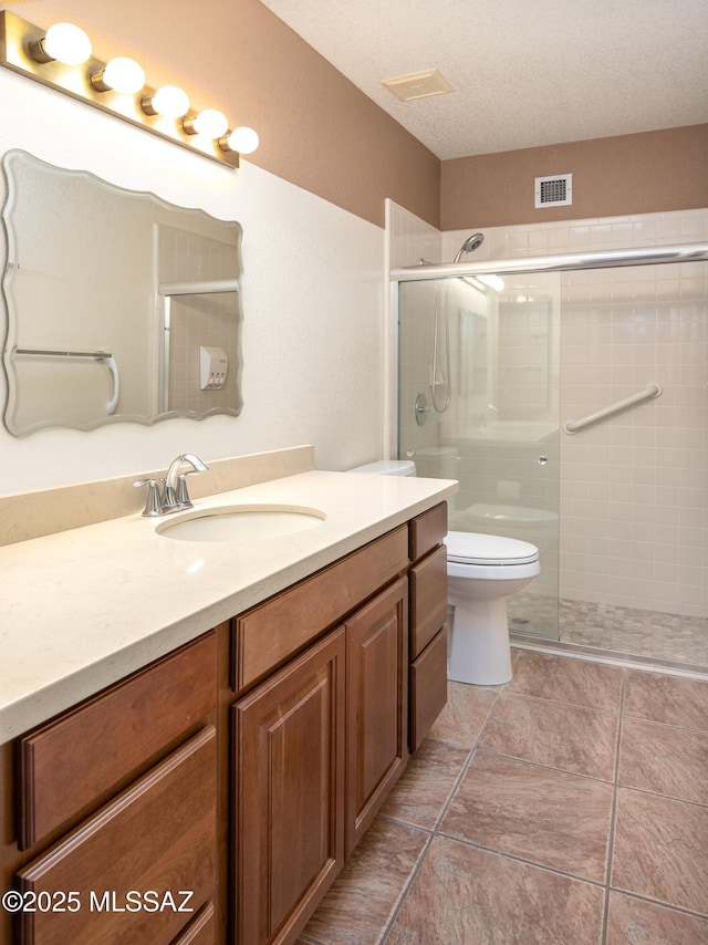 bathroom with vanity, toilet, and a shower with door