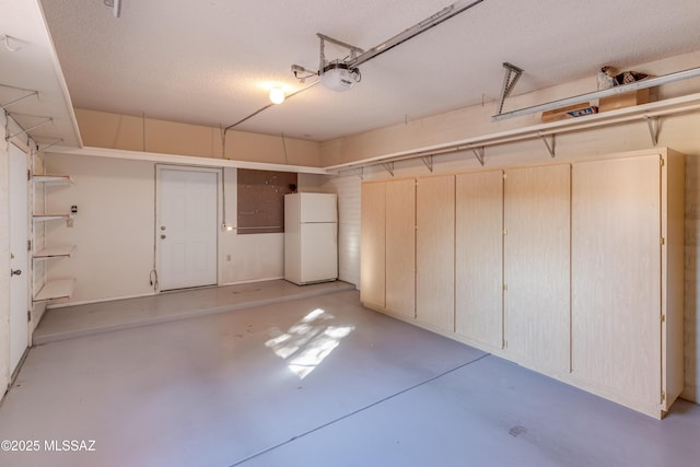 garage featuring white fridge and a garage door opener