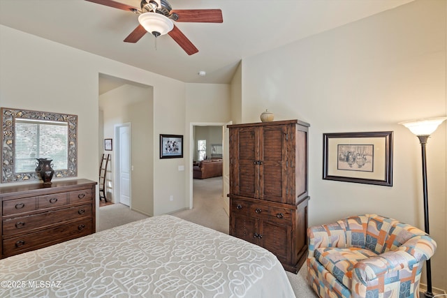 bedroom with ceiling fan, light colored carpet, and vaulted ceiling