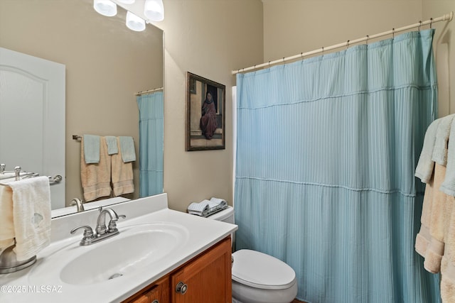 bathroom featuring vanity, toilet, and walk in shower