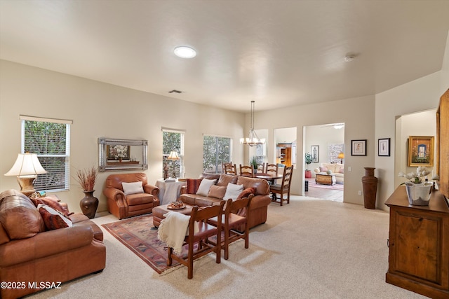 living room with light colored carpet and a chandelier