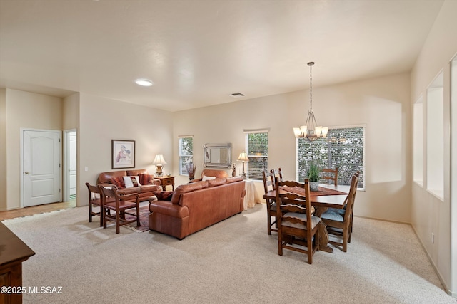 dining space featuring a notable chandelier and light colored carpet