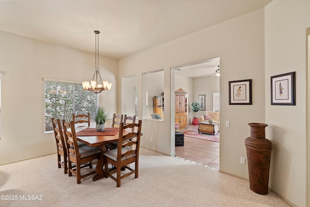 carpeted dining room featuring ceiling fan with notable chandelier