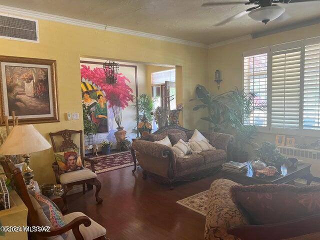 living room with radiator, a textured ceiling, ceiling fan, crown molding, and hardwood / wood-style floors