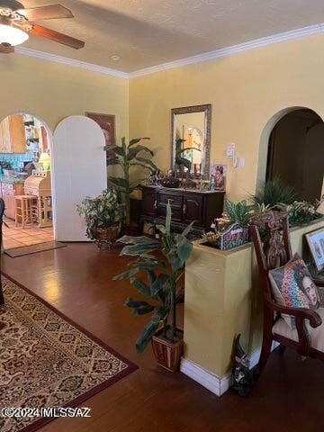 interior space featuring a textured ceiling, hardwood / wood-style flooring, ceiling fan, and ornamental molding