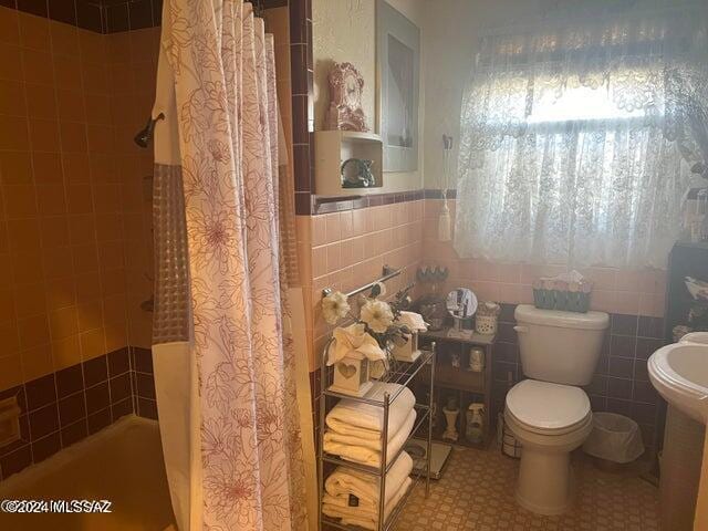 bathroom with toilet, tile walls, and walk in shower