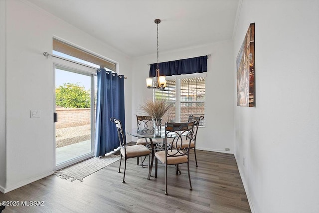 dining space featuring hardwood / wood-style flooring and an inviting chandelier