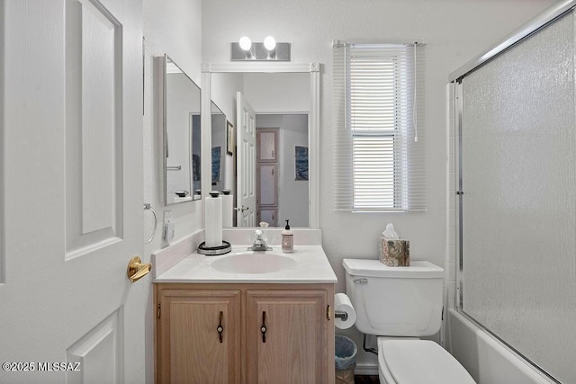 full bathroom featuring vanity, toilet, a wealth of natural light, and combined bath / shower with glass door