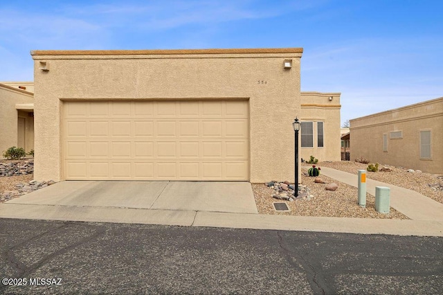 pueblo-style house featuring a garage