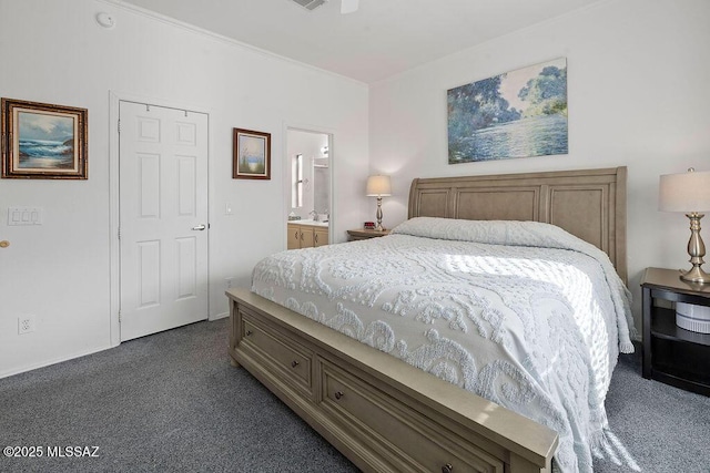 bedroom with dark carpet, sink, and connected bathroom