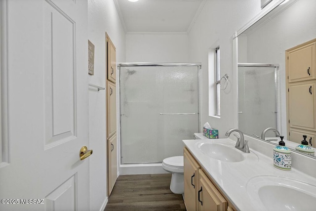 bathroom featuring hardwood / wood-style flooring, toilet, a shower with door, and crown molding