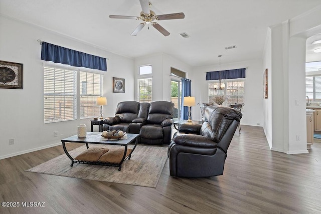 living room featuring ceiling fan with notable chandelier and dark hardwood / wood-style floors