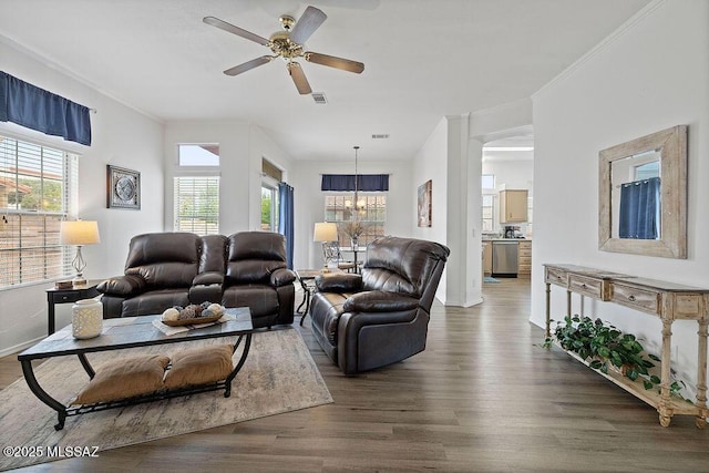 living room with dark hardwood / wood-style flooring and ceiling fan with notable chandelier