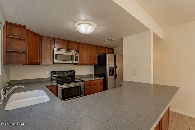 kitchen with kitchen peninsula, light tile patterned floors, stainless steel appliances, and sink