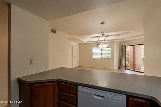 kitchen with white dishwasher, decorative light fixtures, and a tray ceiling