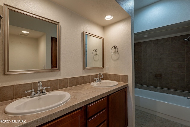 bathroom featuring vanity, tiled shower / bath combo, tasteful backsplash, and tile patterned flooring