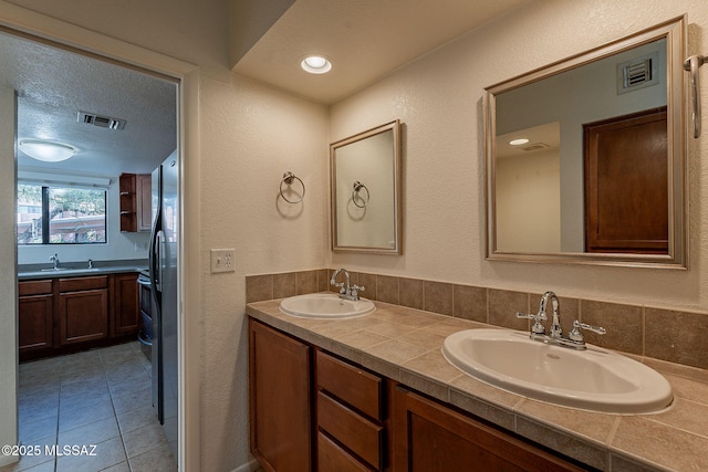 bathroom featuring vanity, a textured ceiling, and tile patterned flooring