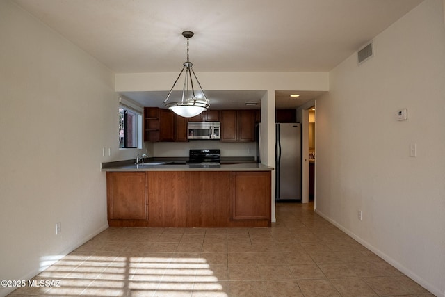 kitchen featuring sink, kitchen peninsula, stainless steel appliances, and hanging light fixtures