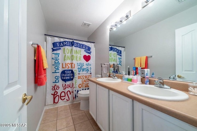 bathroom featuring toilet, vanity, and tile patterned flooring