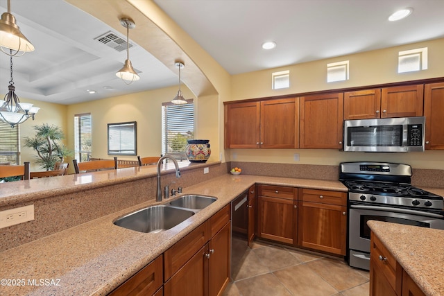 kitchen featuring sink, light stone countertops, stainless steel appliances, and hanging light fixtures