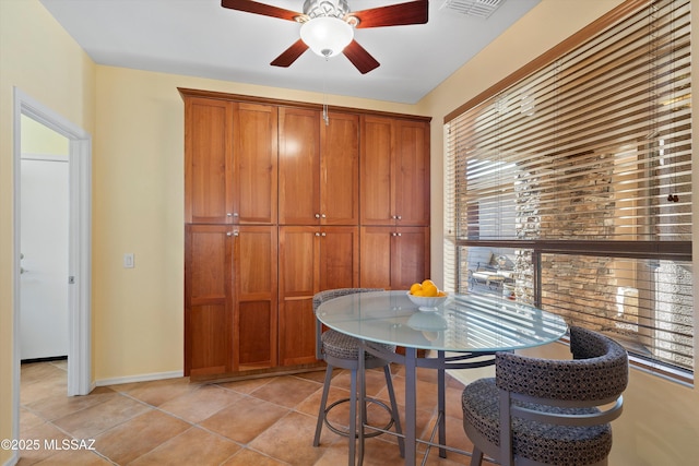 tiled dining space featuring ceiling fan