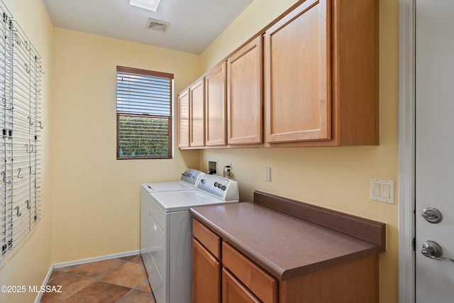 laundry area featuring cabinets, light tile patterned floors, and washer and dryer