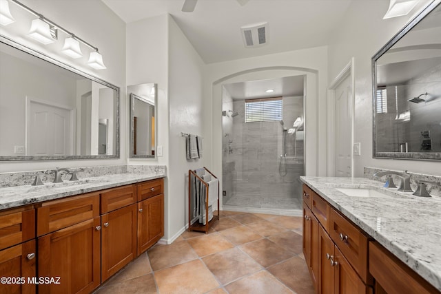 bathroom featuring ceiling fan, tile patterned flooring, vanity, and walk in shower