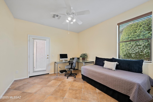 tiled bedroom featuring multiple windows and ceiling fan