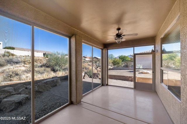 unfurnished sunroom with ceiling fan