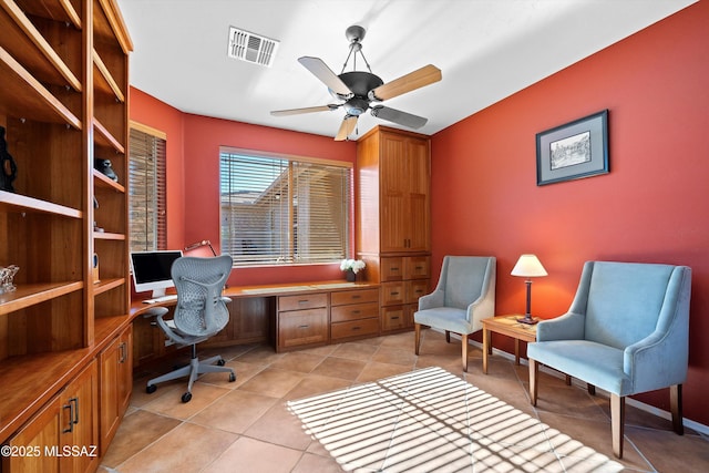 office featuring ceiling fan, light tile patterned flooring, and built in desk